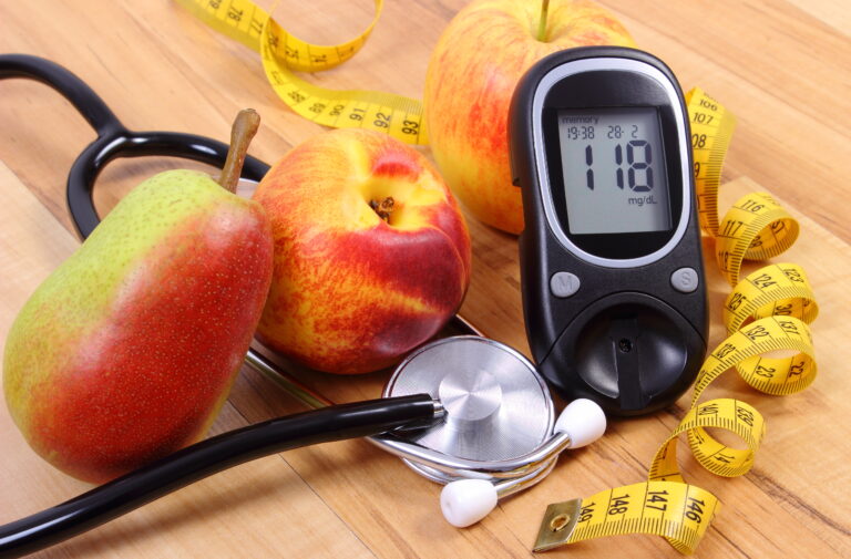 Glucose meter with medical stethoscope and fresh fruits, healthy lifestyle